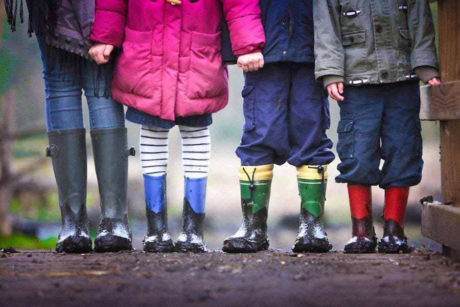 Children standing in a row in colourful wellington boots